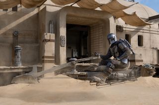 The Mandalorian person on a hover vehicle