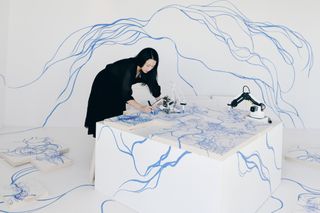 Sougwen Chung drawing with a robot arm