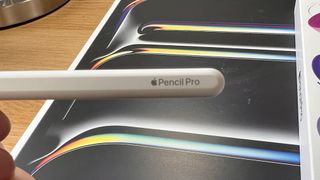 A white Apple Pencil Pro being used with an iPad Pro M4