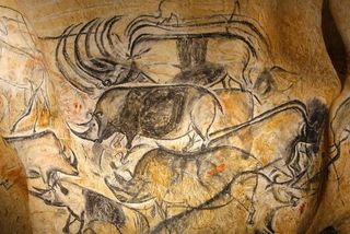 Replica panel of cave painting showing grey rhinos drawn on cave wall