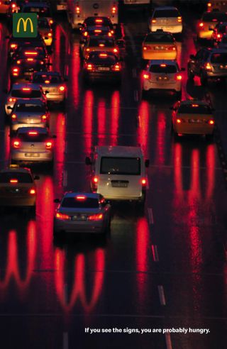 McDonald's ad featuring a group of cars with the McDonald's 'M' reflecting from their headlights