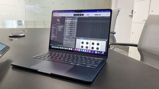 A MacBook Air in an office on a black desk