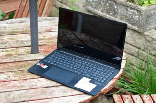 A black ASUS Zenbook 15 OLED laptop sitting on a table