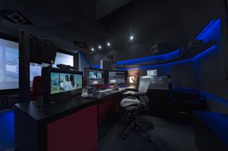 A home studio with many screens and blue lights