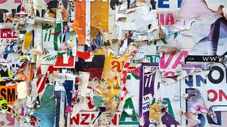 A wall with layers of torn posters using different fonts to represent the importance of font licensing