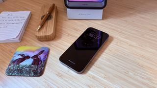 An iPhone 16 Pro on a wooden desk