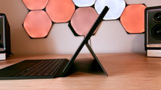 An ASUS ProArt PZ13 laptop on a wooden desk