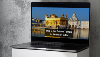 Laptop screen showing video clip of ornate golden Indian building by the water, with subtitles that say 'This is the Golden Temple in Amritsar, India'. Laptop is resting on a stand or plinth.