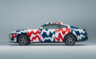 Photograph of the 60th year anniversary celebratory Mustang collaboration with Haus of Thrills. Side view of white Mustang with colourful lines in white, red and blue with an occasional blue background.