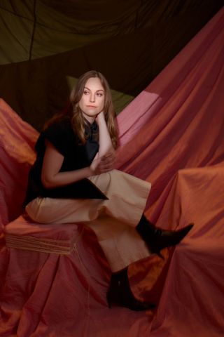 BAFTA Breakthrough 2024 winner; a woman sits on a silk curtain