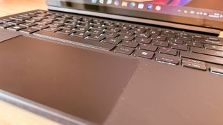 An ASUS ProArt PZ13 laptop on a wooden desk