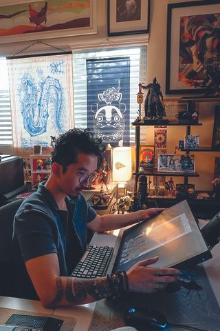 Inside the artist's studio; Erik Ly looking at a large screen