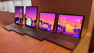 four laptops in a row with a 'welcome to CES' background on their screens